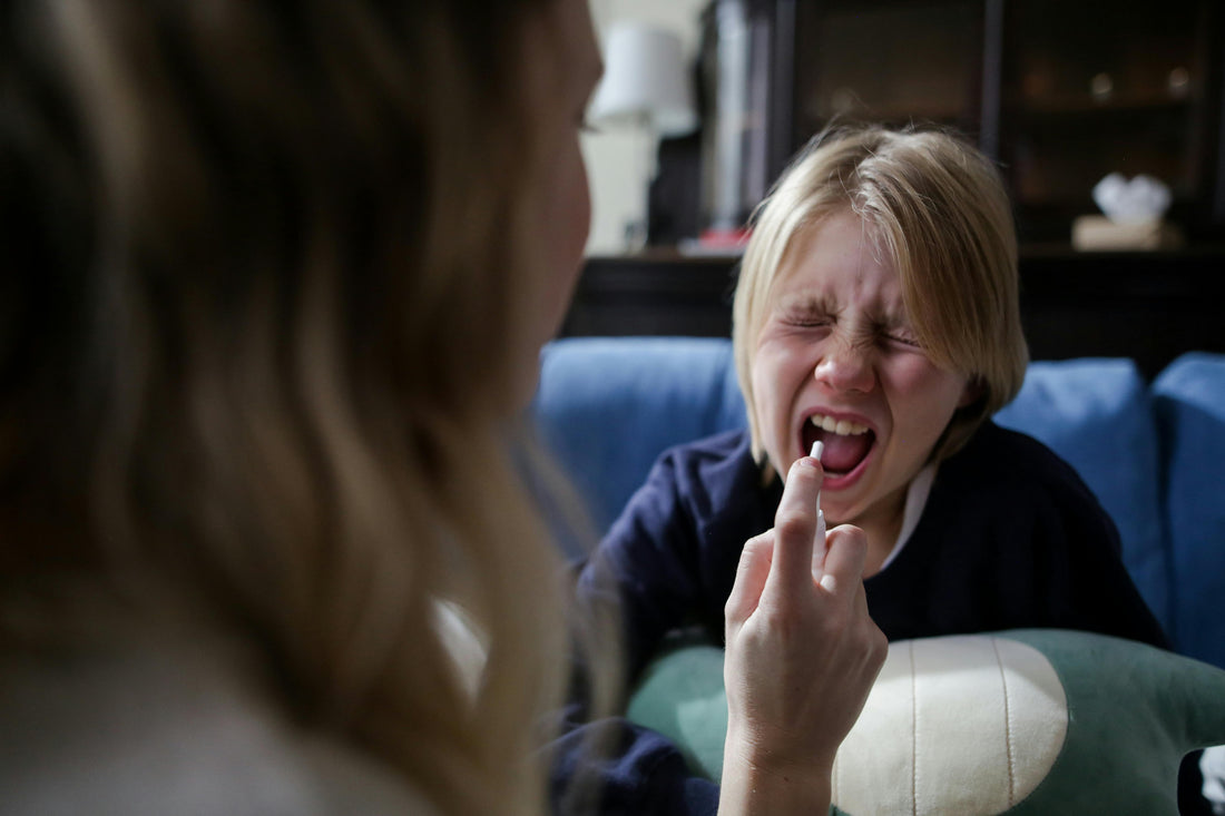 A Woman Using a Medicine Mouth Spray to A boy