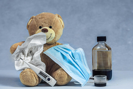 a Teddy Bear beside a Thermometer